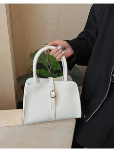 Détail d'un sac à main blanc en similicuir avec boucle argentée et fini texturé