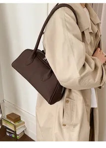 Detail of dark brown lychee pattern leather tote bag with silver zipper and shoulder strap