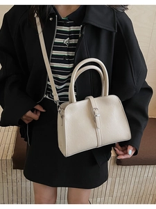 Détail du sac à main blanc crème montrant la texture du cuir et sa boucle métallique chic