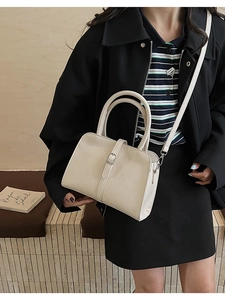 Détail d'un sac à main chic en cuir crème avec des boucles en métal argenté élégantes