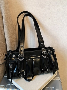 Glossy black shoulder bag with pleat design and silver metal buckles in punk style