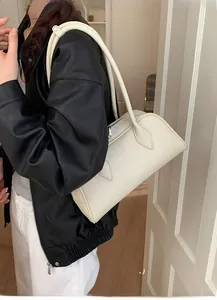 White leather shoulder bag styled on model in a minimalist modern living room setting