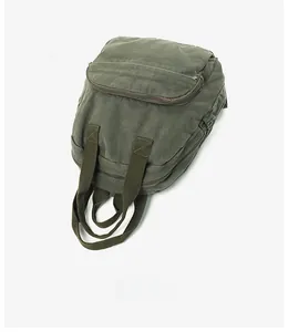 Detail view of military green canvas backpack with durable zippers and reinforced stitching