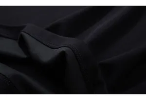 Close-up of high-density black knit fabric with detailed double-stitched hem and matte texture