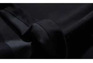 Gros plan sur la texture du tricot noir épais et les coutures d'ourlet de qualité