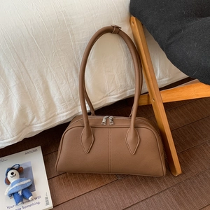 Detail of vintage brown pebble leather handbag with dual zippers and long shoulder handles
