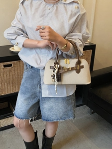 Sac coquille vintage en toile beige et cuir marron porté par un mannequin femme