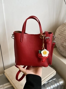 Borsa a secchiello minimalista in pelle rossa con ciondolo a fragola e tracolla