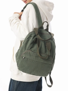 Dark green canvas backpack featuring multiple pockets and adjustable straps for travel