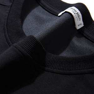 Gros plan sur le t-shirt noir en coton 5XL avec col rond côtelé et étiquette intérieure