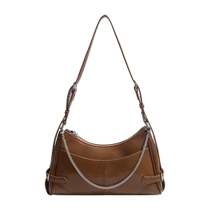 Sac à bandoulière en similicuir marron brillant avec chaîne argentée sur fond blanc neutre