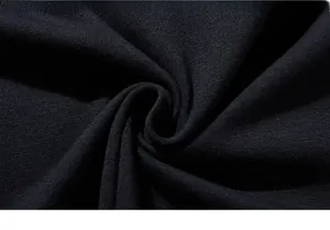 Close-up of premium black cotton knit fabric showing soft texture and flexibility