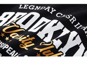 Détail macro de l'imprimé style Brooklyn varsity avec dorure sur sweat-shirt noir