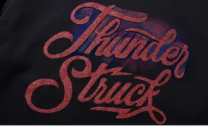 Detail view of red glitter Thunder Struck print on black cotton sweatshirt fabric