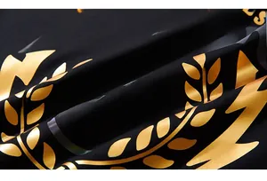 Macro view of gold laurel leaf and colorful 79 MOTO logo print on black knit sweatshirt