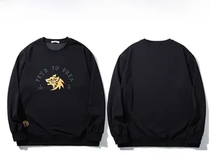 Detailed view of black crewneck sweatshirt with golden wolf head print and logo detail