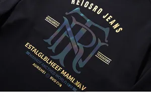 Macro detail of men's black knit T-shirt with laser-cut TR logo and yellow 3D print