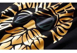 Detail of black T-shirt featuring golden graphic print with laser reflective sunglass element