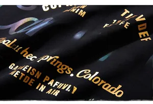 Dettaglio macro della stampa riflettente multicolore e lamina d'oro su cotone nero
