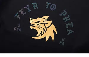 Macro detail of the golden wolf head logo with colorful reflective print on black fabric
