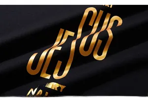 Macro detail of the gold metallic foil lettering on black premium combed cotton fabric