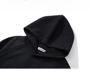 Detail of the hooded neckline and thick knitted texture on a black oversized hoodie