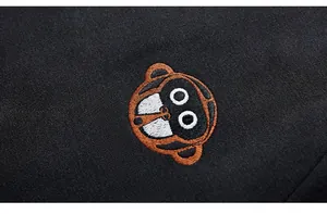 Close-up of premium cartoon monkey embroidery and white lettering on black hooded sweatshirt