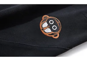Macro shot of CIUGEJIA embroidery with monkey motif on black heavy hooded tracksuit