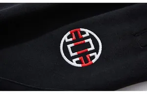 Detail of red and white circular embroidery on black hoodie sleeve with high quality stitching