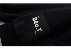 Detailed close-up of embroidered black patch with Beu.T text on hoodie sleeve