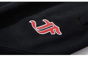 Close-up of high-quality red and white logo embroidery on premium black knit fabric