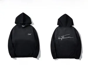 Detailed close-up showing black embroidered cotton hoodie with white script branding