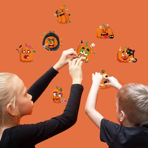 Kids decorating an orange wall with Halloween pumpkin stickers and spooky faces