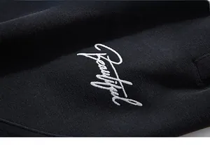 Detailed view of white Beautiful embroidery on black knitted hoodie fabric
