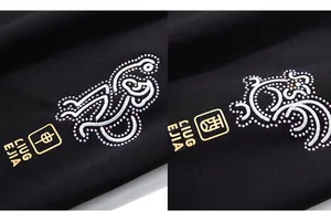 Gros plan sur la broderie de singe en strass blancs et logo doré sur le pantalon noir