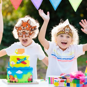 Kids wearing fox paper glasses and monkey headband at an outdoor animal party