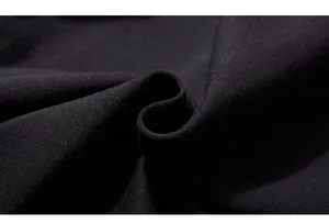 Gros plan d'un tissu en maille noire montrant la texture épaisse du coton et les détails