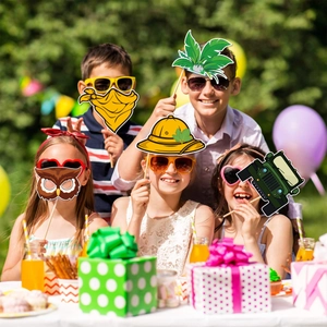 Kids wearing jungle party photo props including owl mask and adventure hat in the garden