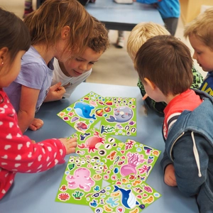 Kinder spielen mit bunten Meerestier-Aufklebern wie Walen und Oktopussen