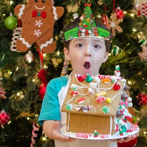 Gros plan d'un enfant portant une couronne de Noël en papier vert avec motifs festifs