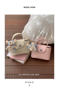 Detail of vintage square crossbody bags in cream and pink with cute teddy bear pendants
