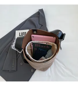 Intérieur spacieux du sac seau en daim kaki montrant le rangement pour ordinateur