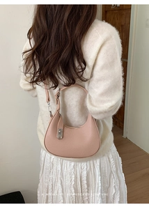 Rosa Hobo-Tasche aus Leder mit Lychee-Muster am Modell für minimalistischen Retro-Look
