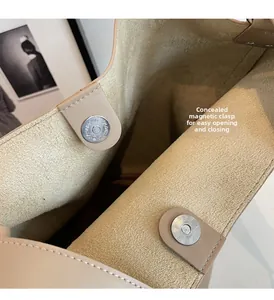 Close-up of invisible magnetic closure on a beige leather tote with suede lining