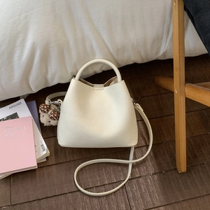 Minimalist beige bucket bag with cute bear charm and adjustable strap for women