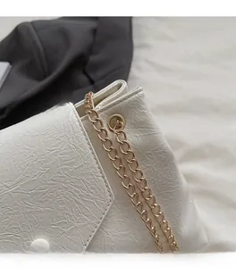 Vue détaillée du sac cabas blanc crème en cuir texturé avec chaîne dorée pâle