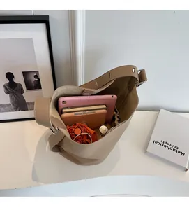 Spacious interior of beige leather bucket bag showing tablet, phone, and umbrella