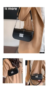 Detail of black leather underarm bag with silver geometric G-buckle and chain strap