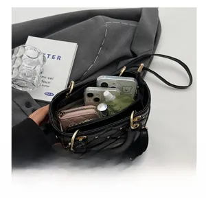 Internal capacity of quilted black crossbody bag showing phone, wallet and lipstick