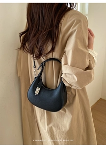 Detail der schwarzen Hobo-Tasche aus genarbtem Leder mit silberner Schnalle am Modell